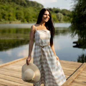 Relaxing young woman standing on wooden pier at the calm lake